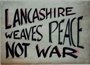 A handmade poster that reads Lancashire Weaves Peace Not War in large capital letters, black on a white background.