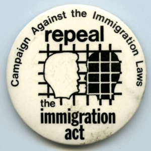 White badge with black text that reads, "Repeal the Immigration Act" in the middle of the badge, with the name of the organisation, Campaign Against Immigration Laws around the edge of the badge. 