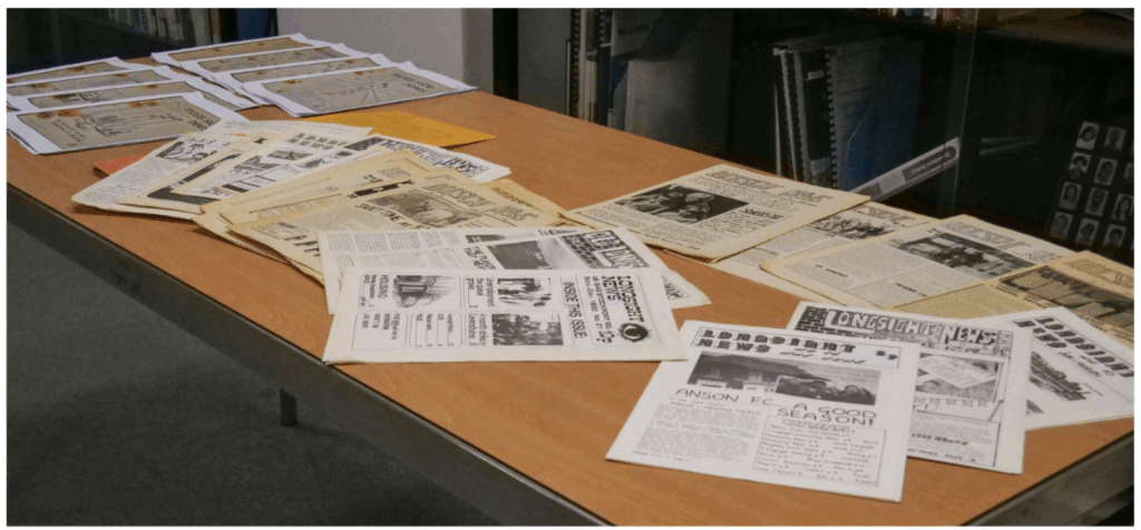 A photo of some People's Papers on a table. 